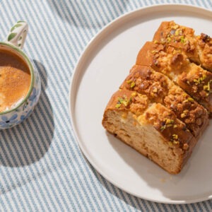 Banana nut flavored coffee brewed in a cup next to a plate of banana bread