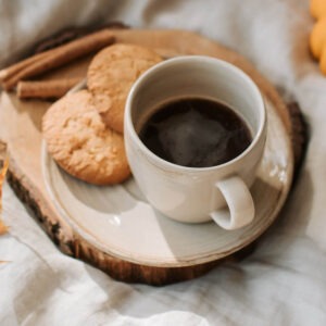 Cinnamon Nut Creme flavored coffee in a cup with cookies on a plate next to the cup