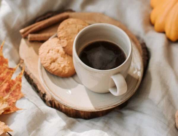 Cinnamon Nut Creme flavored coffee in a cup with cookies on a plate next to the cup