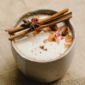 Spiced Butter Rum flavored coffee in a mug with cinnamon sticks over top