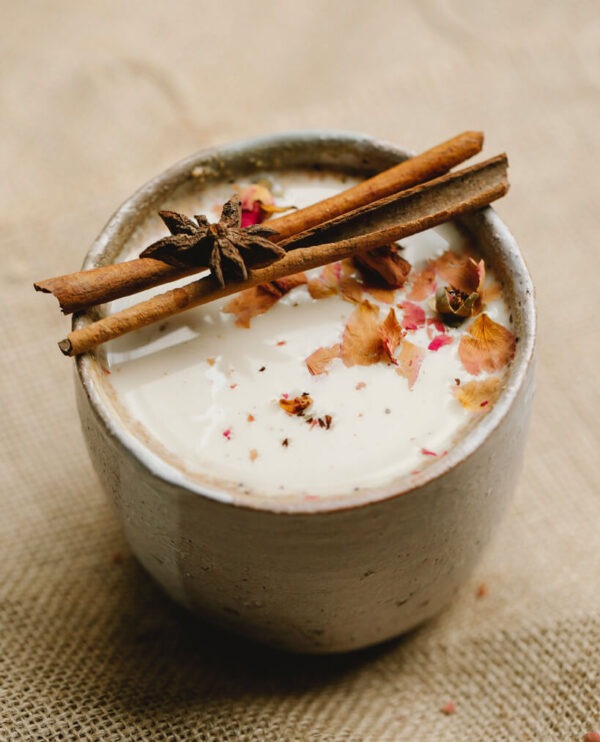 Spiced Butter Rum flavored coffee in a mug with cinnamon sticks over top