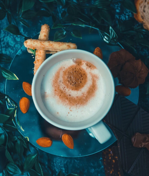 Vanilla almond flavored coffee in a cup on a saucer with two almond cookies