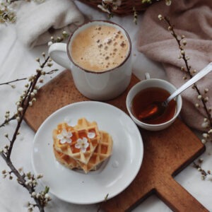 Vermont Maple Nut flavored coffee on a tray with waffles and maple syrup