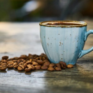 Decaf blend coffee in a cup with coffee beans surrounding